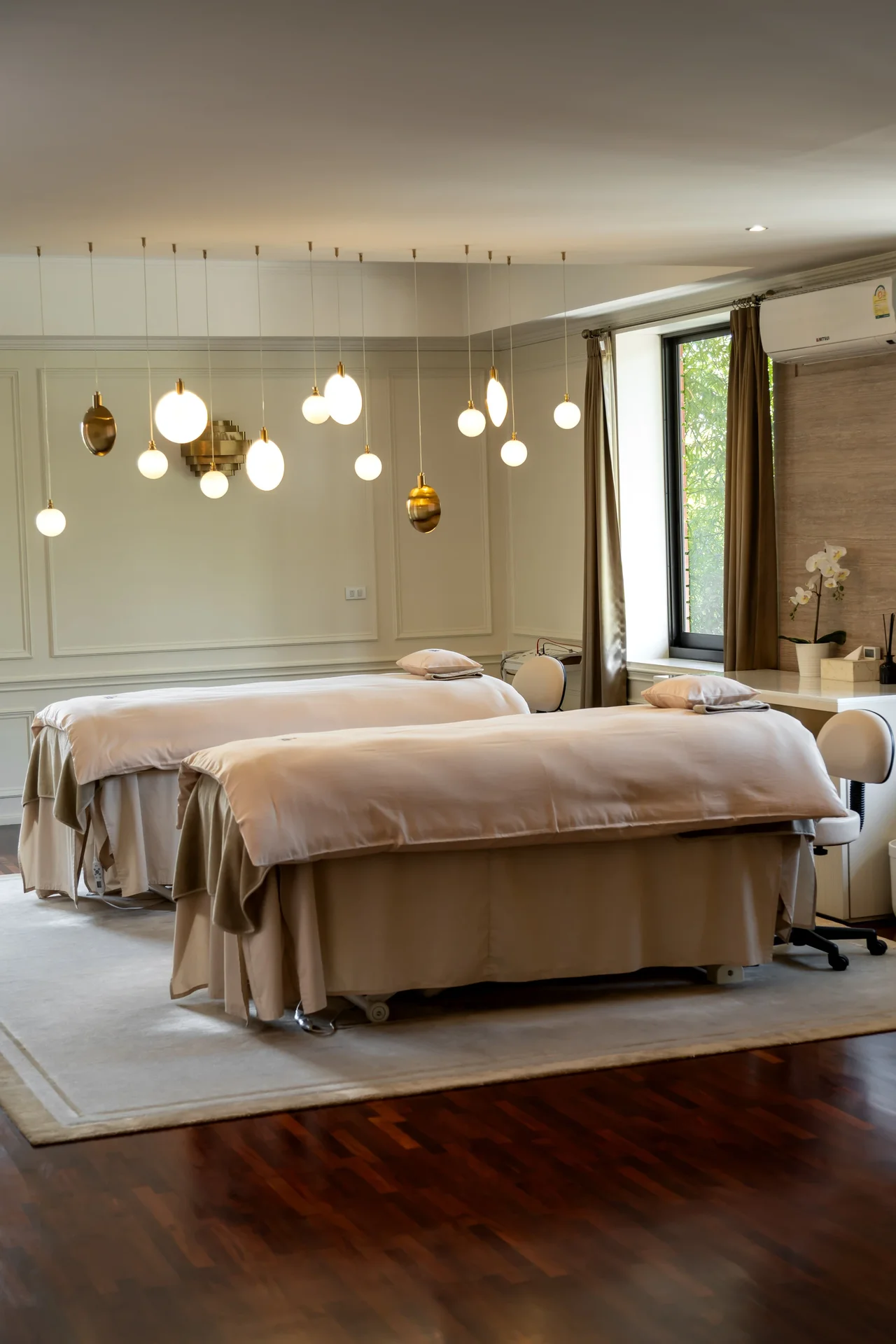 SÉREN Le Moment treatment room with warm pendant lighting and two treatment beds